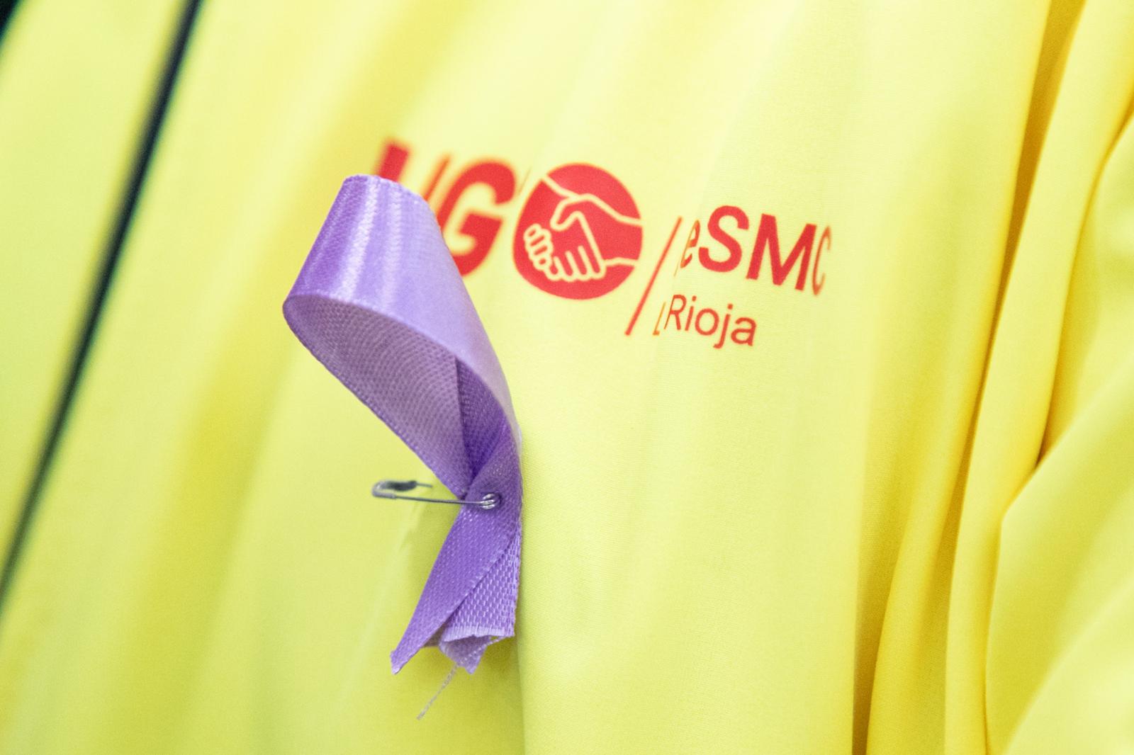 Un lazo morado en un chaleco de un miembro de UGT.