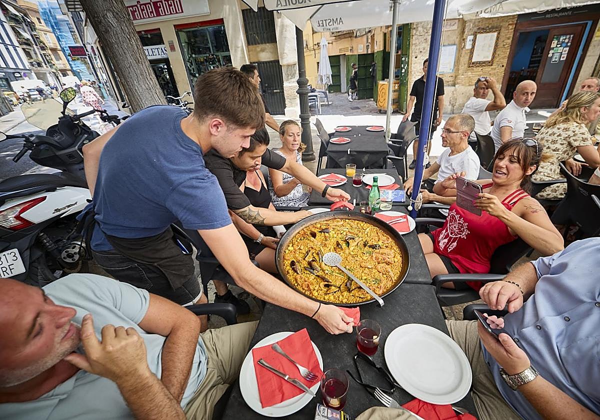 Un restaurante valenciano sirve una paella en su terraza.