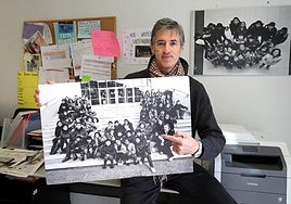 Carlos Villar Flor, en la sede de ASUR, con una foto antigua de voluntarios y beneficiarios de la asociación.