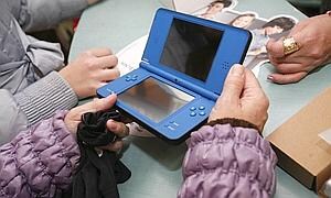 Una joven sostiene una Nintendo DS. / Archivo