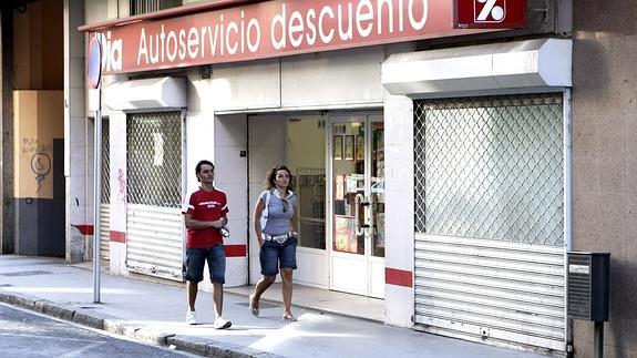 Dos transeúntes pasan ante un supermercado Dia en Miranda de Ebro. 