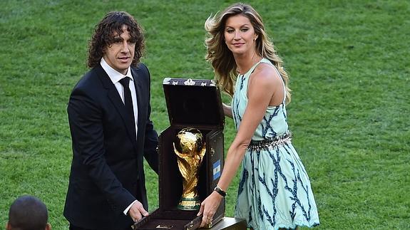 Carles Puyol y Gisele Bundchen portan la copa del campeón. 