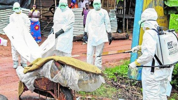 Enfermeras desinfectan una víctima en Monrovia.