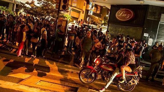 Los transeuntes circulan por una calle de Caracas en la oscuridad, durante el apagón del pasado diciembre 