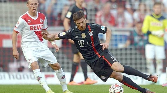 Adam Matuschyk observa a Xabi Alonso durante el partido entre Colonia y Bayern Munich 
