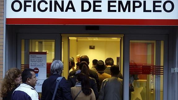 Varias personas hacen cola para entrar a una Oficina de Empleo.