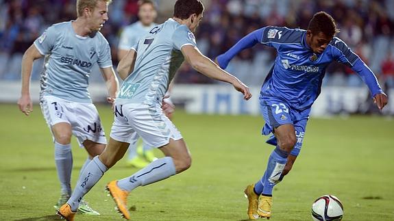 Javi Lara (d) conduce el balón ante los jugadores del Eibar. 