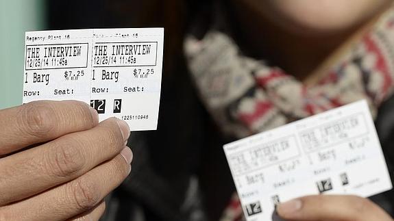 Un hombre enseña unas entradas para el estreno de la película. 