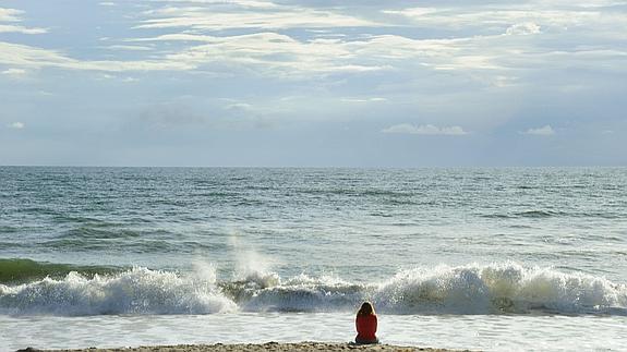 Mujer contempla el océano Atlántico en una playa de Florida. 