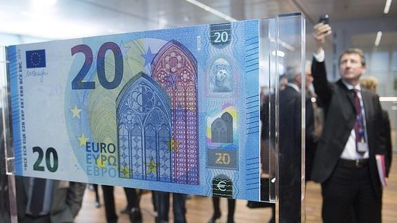 Un hombre fotografía el nuevo billete de 20 euros. 