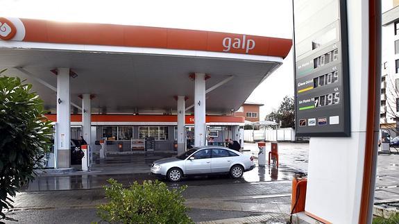 Un coche repostando en una gasolinera. 