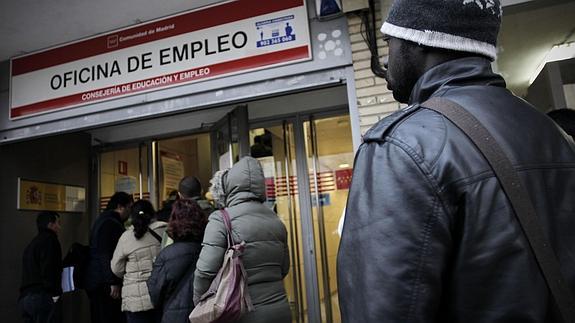 Desempleados haciendo cola en una oficina de empleo. 