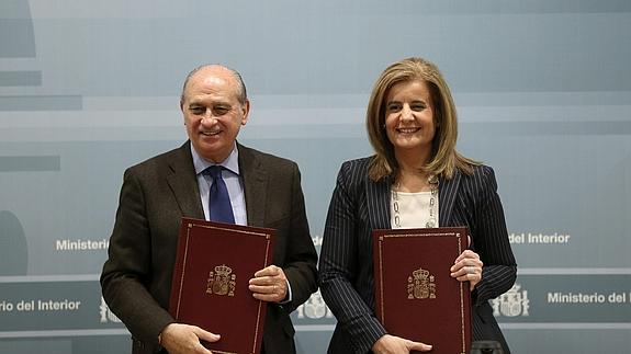 Jorge Fernández-Díaz y Fátima Báñez, durante la firma del convenio.