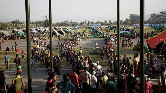 Supervivientes hacen cola para recoger alimentos un día después del nuevo terremoto, en un campamento en Katmandú (Nepal) .