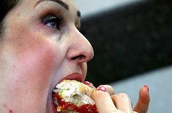 Una mujer come un bocadillo con ansiedad. 