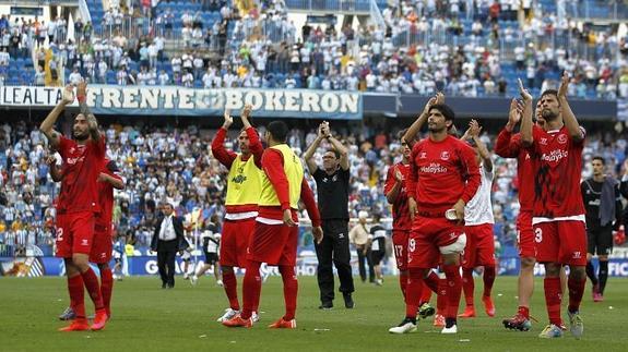 Los jugadores del Sevilla aplauden a su afición en La Rosaleda. 