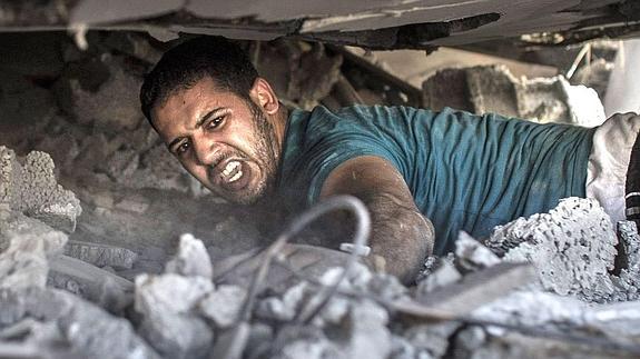 Un palestino busca supervivientes entre los escombros de una casa destruida por un ataque aéreo israelí. 