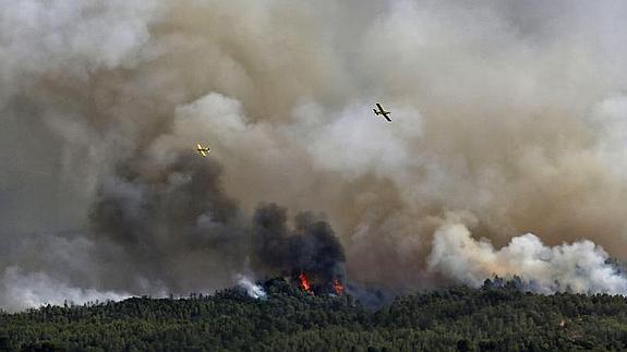 Varios aviones combaten el fuego que avanza hacia Sant Salvador de Guardiola. 