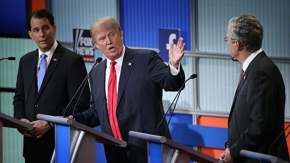 Donald Trump se dirige a Jeb Bush en presencia de Scott Walker. 