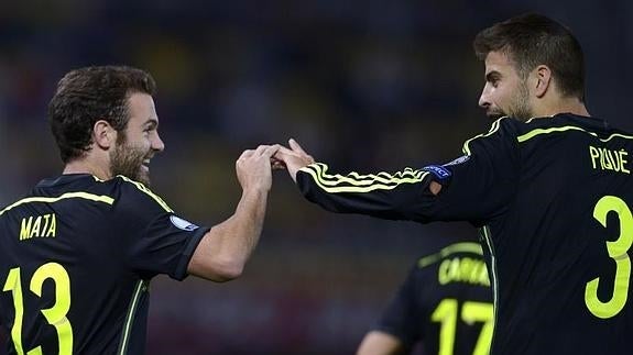 Juan Mata celebra su gol con Gerard Piqué. 