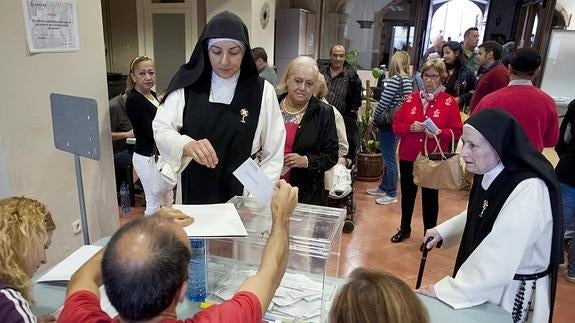 Dos monjas depositan su voto.