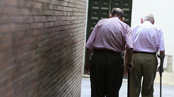 Dos pensionistas caminan por una calle de Sevilla.