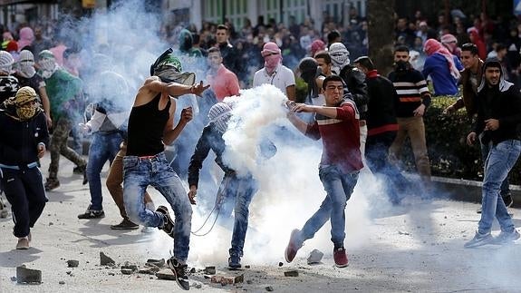 Manifestantes palestinos lanzan piedras contra soldados israelíes.