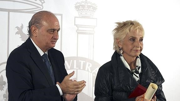 Jorge Fernández Díaz, tras hacer entrega de una de las medallas a la madre del ertzainza Jorge Díez durante un acto en Bilbao.