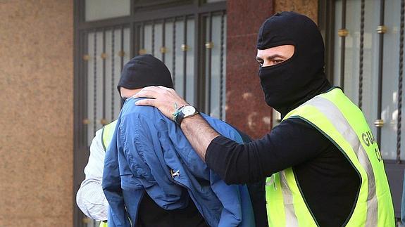 Agentes de la Guardia Civil trasladan al presunto yihadista detenido en Cornellá.