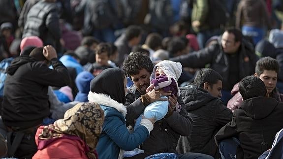 Varios refugiados esperan para coger un tren en el punto fronterizo de Grecia y Macedonia.