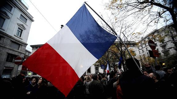 Una persona porta una bandera francesa.