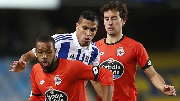 El delantero brasileño de la Real Sociedad Jonathas (c) pelea un balón con Mosquera (d) y el brasileño Sidnei (i), ambos del Deportivo de La Coruña.