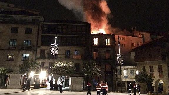 Los Bomberos de Pontevedra tratan de sofocar un incendio en el centro histórico de la ciudad.