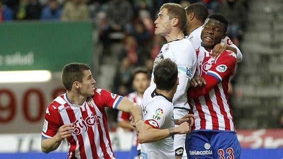 Varios jugadores saltan por el balón. 