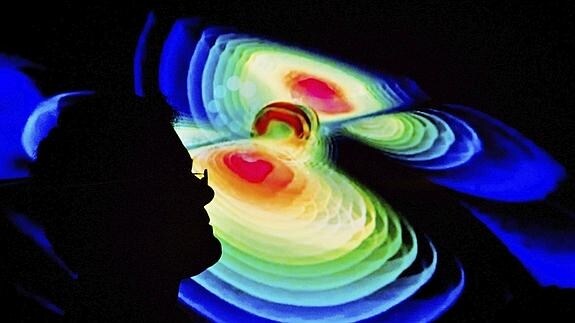 Un científico observa una representación de las ondas gravitacionales.
