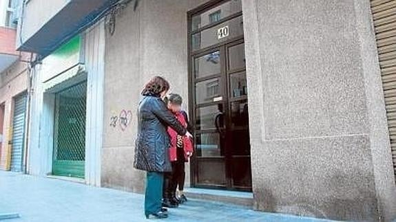 Una mujer señala la puerta del edificio donde abandonaron a la niña recién nacida.