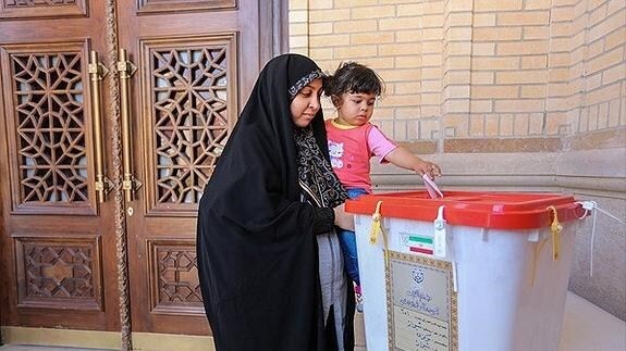 Una mujer vota con su hija en Shiraz. 