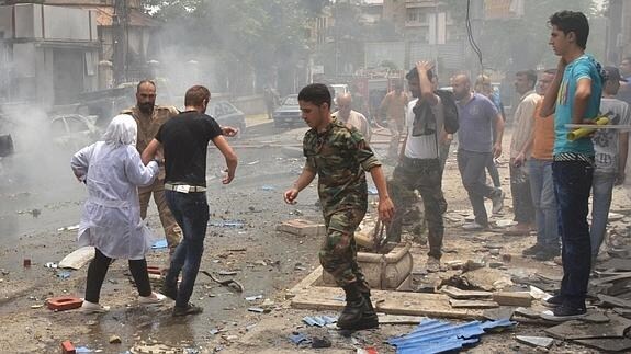 Fuerzas de seguridad sirias evacúan al personal médico del hospital atacado. 