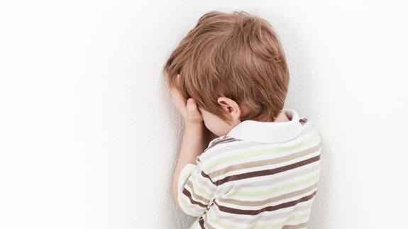 Niño castigado en un rincón.