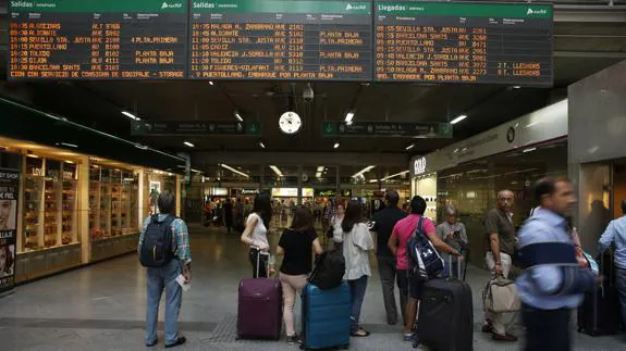 Viajeros miran los horarios en la estación de Atocha en la primera de las jornadas de huelga.