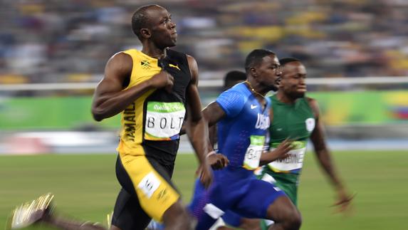 Bolt se señala a sí mismo al cruzar la meta. 