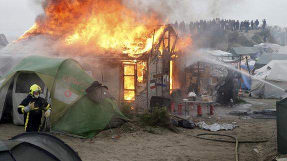 Varios bomberos tratan de extinguir el fuego.