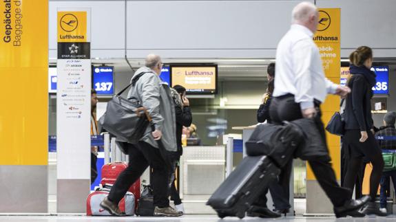 Pasajeros esperan en los mostradores de facturación de Lufthansa en el aeropuerto de Düsseldorf (Alemania). 