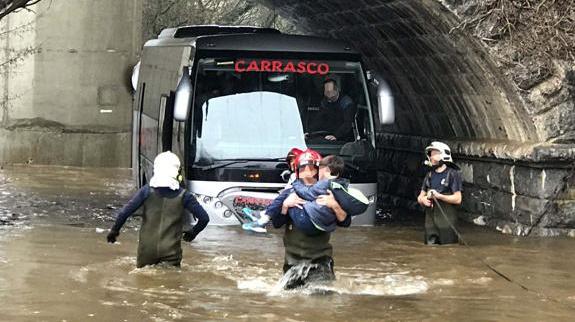 Un bombero saca a un menor del autobús.