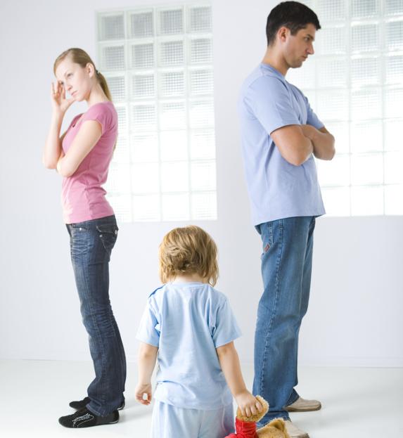 Padres de espaldas e hija en medio durante una discusión.