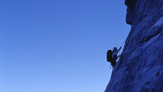 Una persona practicando escalada en los Alpes. 