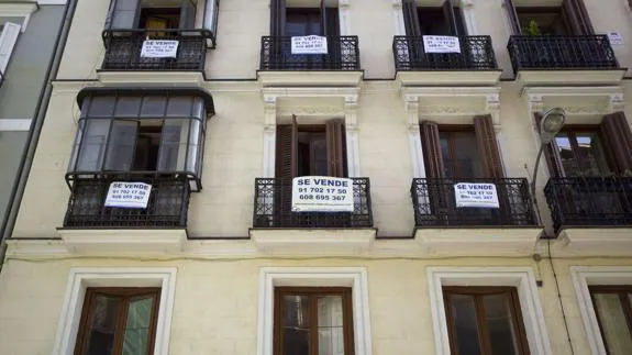 Bloque de apartamentos del centro de Madrid con carteles de "Se Vende".