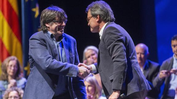 El presidente de la Generalitat, Carles Puigdemont (i), y el líder del PDeCAT, Artur Mas (d).