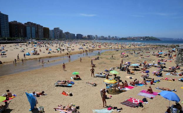 Playa de Gijón llena de turistas.