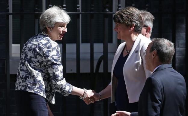Theresa May estrecha la mano de Arlene Foster.